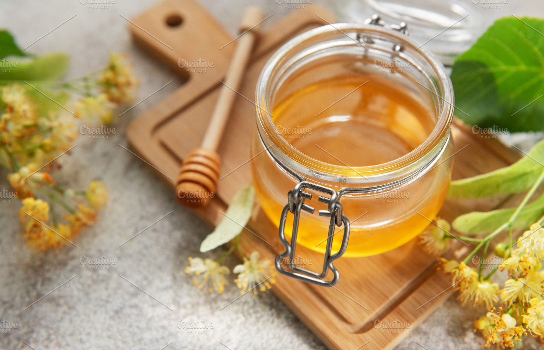 Fresh linden honey jar with blooming flowers, a Food & Drink Photo by Olena Rudo
