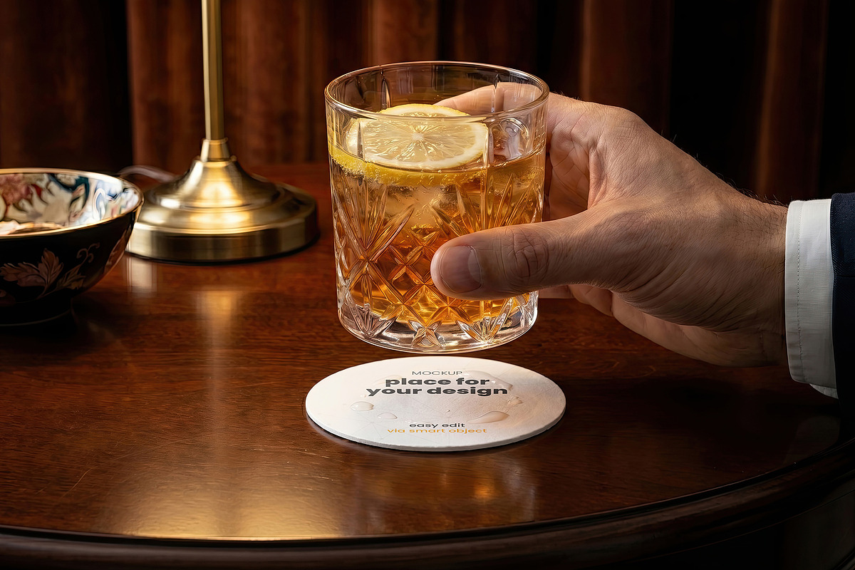 Coaster with Drink and Hand Mockups, a Merchandise Mockup by Luuqas Design (Photo 1 of 3)
