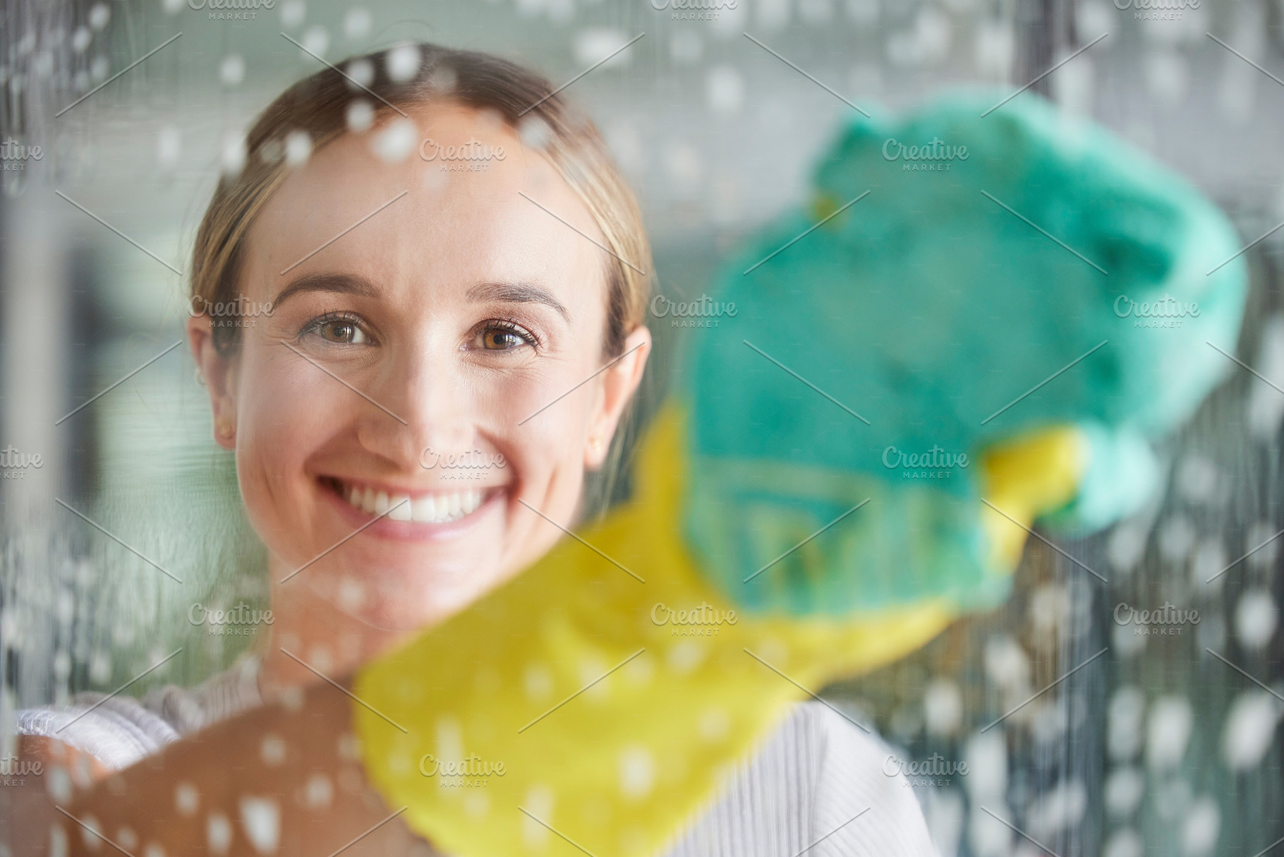 Cleaning, washing and portrait of woman by window with foam, cleaning products and cloth for housework. Spring cleaning, housekeeping and happy girl wipe dirt and dust on glass window for clean home, a Photo by Peopleimages.com