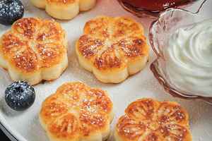 Cottage cheese pancakes, syrniki, curd fritters decorated with strawberry and r, a Food & Drink Photo by Budarinphoto