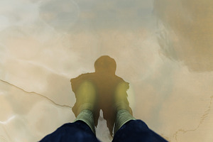 POV shot of person with Rain Boots standing in Floodwater., a Photo by salmon.black