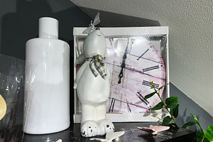 Stylish decorative arrangement with clock, sculpture, and greenery on a dark sh, a Photo by AS photostudio