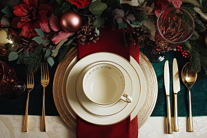 Elegant Christmas dinner table setting with festive decorations, golden cutlery, a Food & Drink Photo by Anneleven
