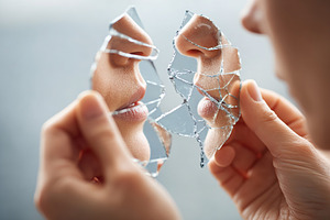 Reflections of self in shattered glass reveal inner conflict and vulnerability, a Photo by AlyaAnd