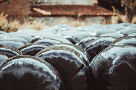 Wrapped hay bales in countryside, an Industrial Photo by SkyNext