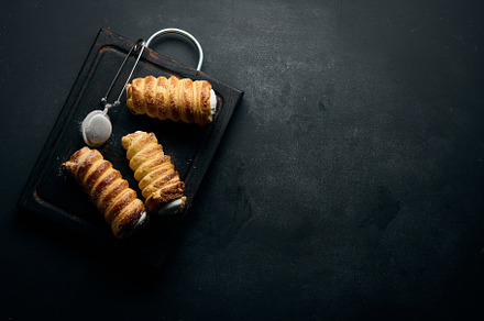 baked tubules filled with whipped egg white cream on a black woo, a Food & Drink Photo by ndanko