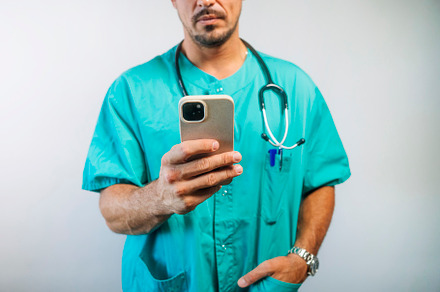 Doctor Using Smartphone in Scrubs