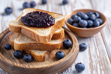 Toast breads with sweet blueberry jam on wooden table, a Food & Drink Photo by AlyaAnd