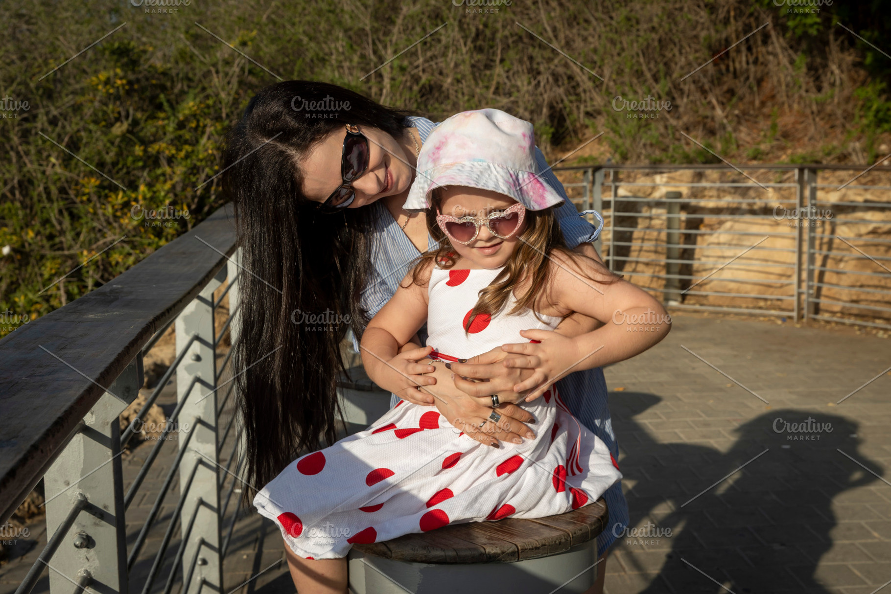 Loving mother hugging her young daughter from behind on a sunny, a Person Photo by Imaginarium