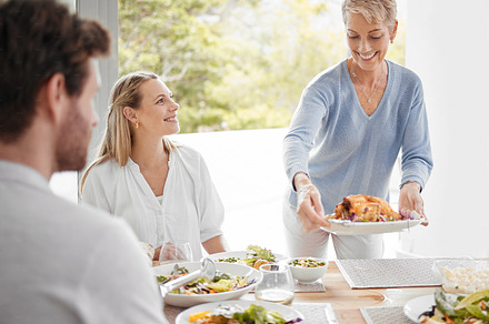 family, relax and dinner together in family home for happiness, big family conversation or healthy food at table. Happy lifestyle, women and man smile, eating lunch and luxury celebration in home, a Photo by Peopleimages.com