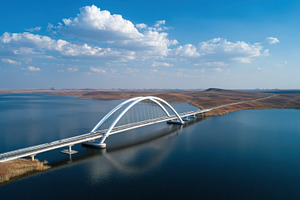 Bridge over wide river, blue sky, a Photo by Beautiful things