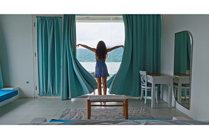Woman opening curtains seeing view, a Person Photo by Goinyk