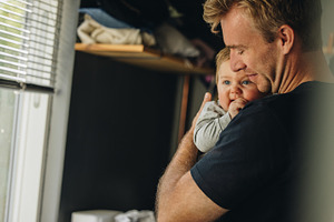 Father consoling his baby at home, a Person Photo by Jacob Lund