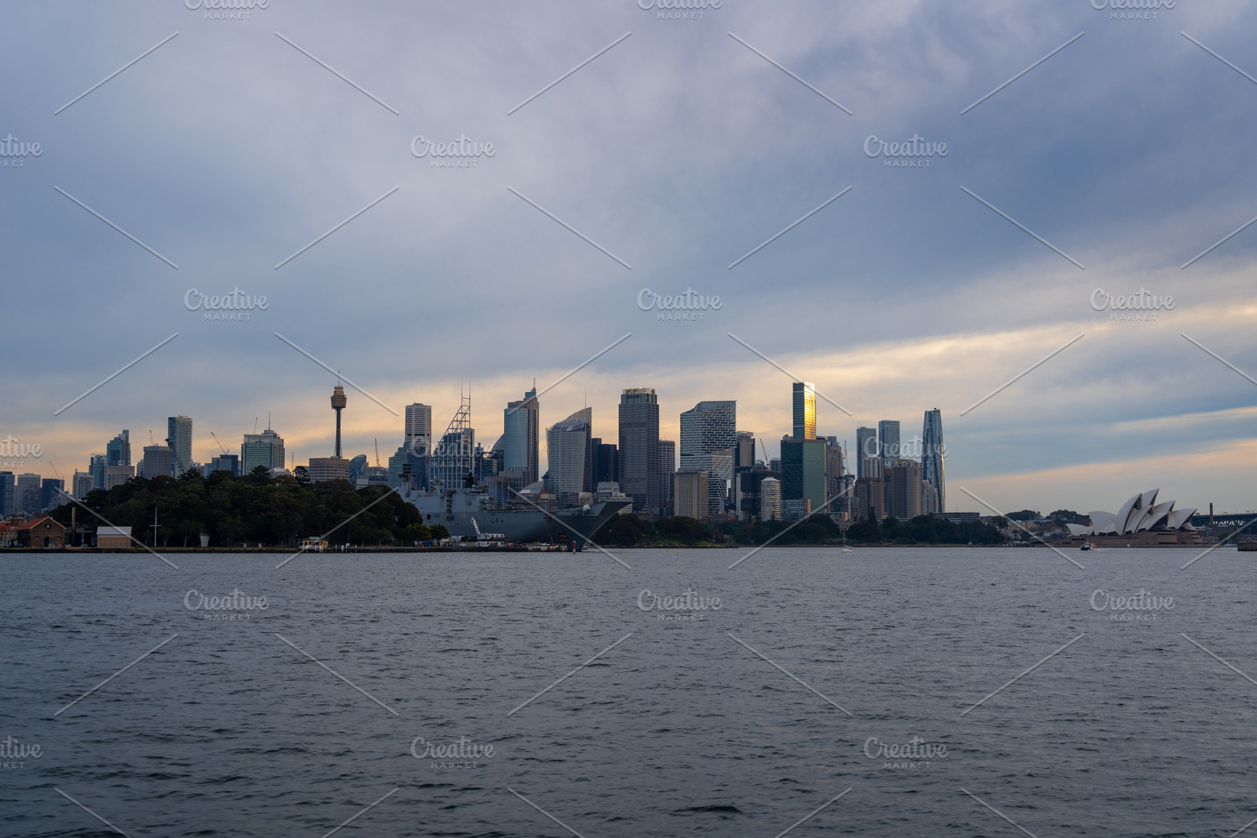 Sydney skyline at sunset with golden reflections on the water, an Architecture Photo by GoodGoods