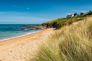 Coastal scene with golden sand beach, turquoise ocean water, roc, a Photo by Studio ANNA