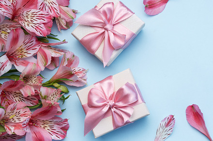 Beautiful Alstroemeria flowers and gift boxes on blue background, a Holiday Photo by Olena Rudo