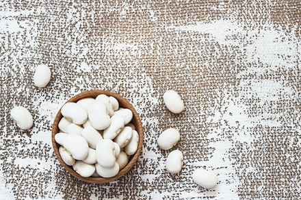 White navy beans in wooden bowl als containing bean, common, and white