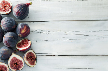 Fresh figs with copyspace on wooden table, a Food & Drink Photo by AlyaAnd