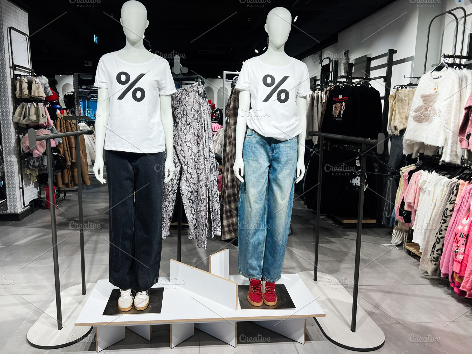 Two mannequins wearing casual clothing in a modern retail fashion store display, a Photo by AS photostudio