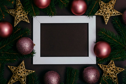 Picture frame and pink christmas baubles composition on brown ba, a Holiday Photo by hitdelight