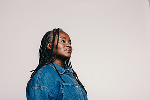 Woman with dreadlocks looking away thoughtfully in a studio, a Person Photo by Jacob Lund