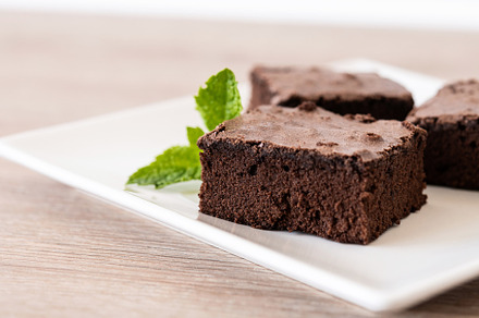 Chocolate brownie portion on wooden table, a Food & Drink Photo by etorres69