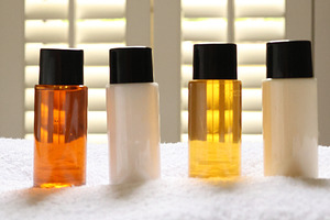 Travel size toiletries arranging on white towel in hotel bathroo, a Photo by Studio ANNA