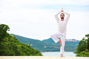 Man doing indian classic yoga at the sea and mountains stock photo containing
