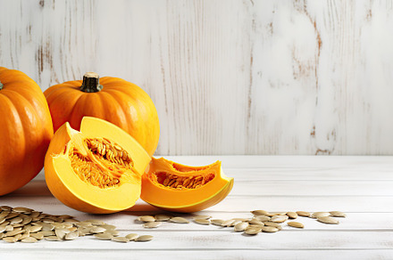 Orange pumpkins with seeds on white wooden background, a Photo by AlyaAnd