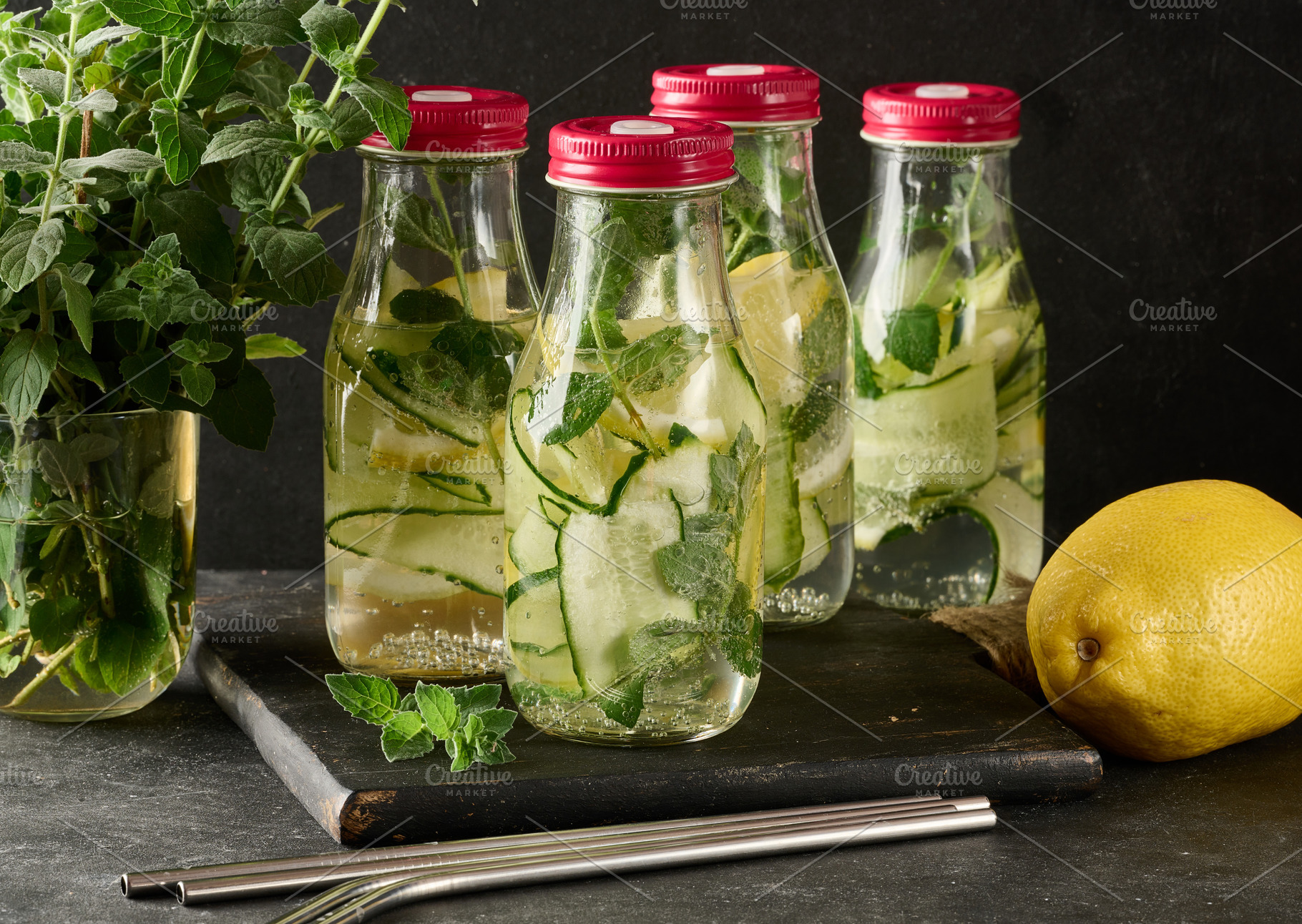 Group of glass bottles with red lids, filled with detox water, c, a Food & Drink Photo by ndanko