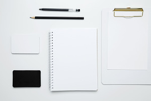 Monochrome stationery items. On a white background, an empty mock up notebook a, a Photo by matucha