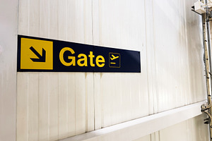 Gate sign directing travelers at an airport terminal wall in Manchester with bo, a Photo by AS photostudio