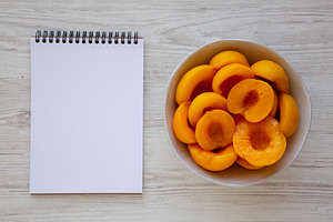 Healthy Organic Canned Peach Halves in a Bowl, blank notepad, to, a Food & Drink Photo by LiudmylaChuhunova
