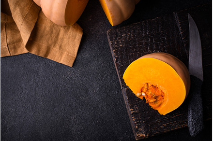 Raw fresh cut pumpkin on dark