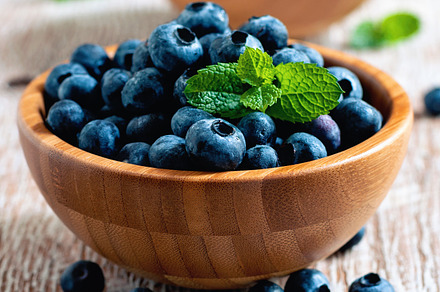 Blueberries in wooden bowls featuring blueberries, background, and berry