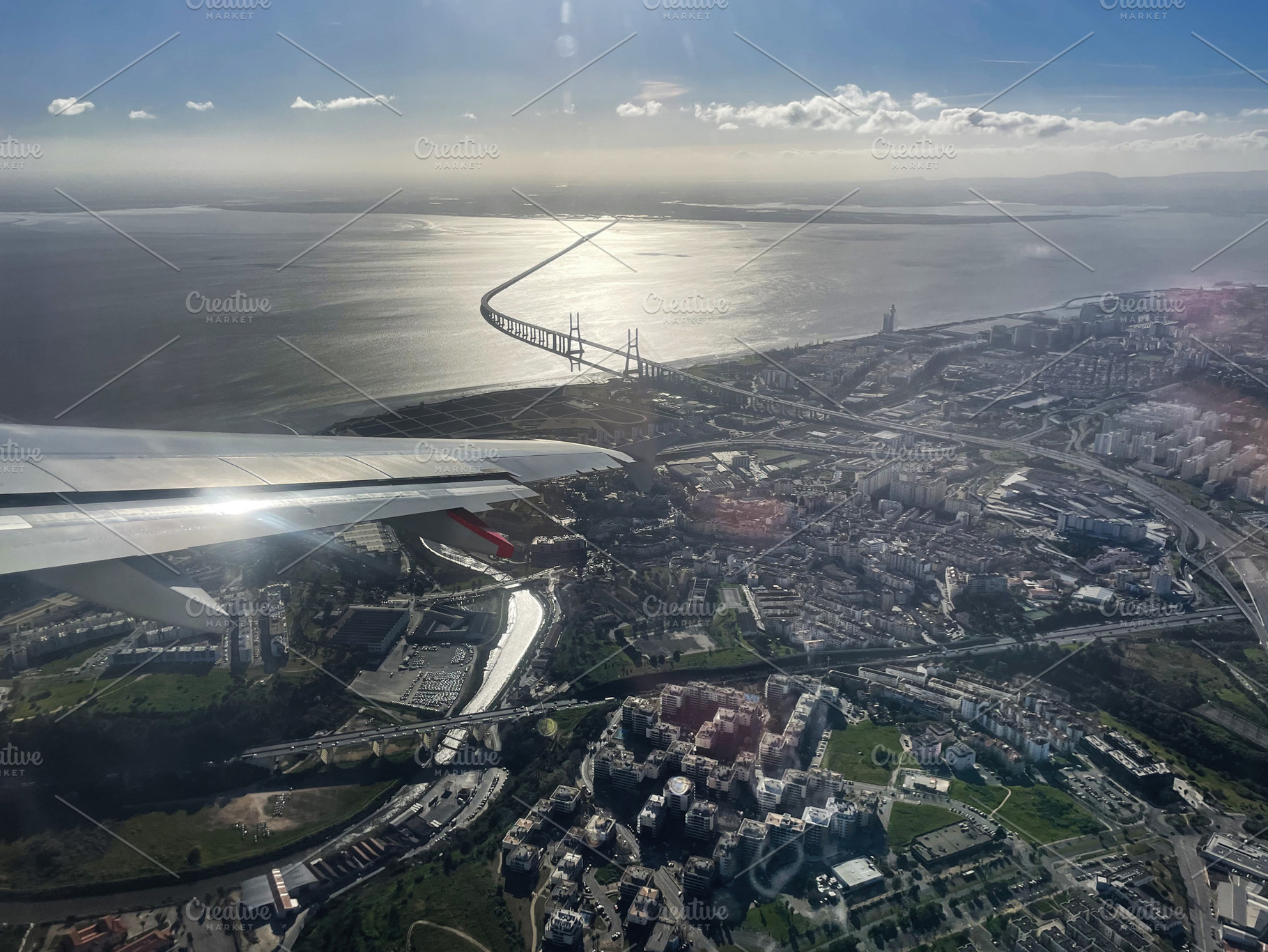 Aerial view of Lisbon, Portugal with river and bridge under bright sunny sky, a Photo by AS photostudio