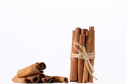 dry cinnamon sticks tied with a rope on a white background, a Food & Drink Photo by ndanko