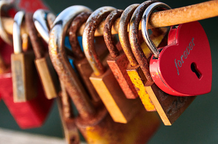 Love locks weathered on a chain on a bridge