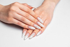 Woman hands showing stiletto nail art manicure wearing white gli, a Beauty & Fashion Photo by Olena Rudo