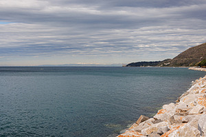 Large stones near green hills and Miramare Castle visible in the background und, a Nature Photo by Bepslabor