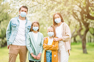 Adorable family in blooming cherry g stock photo containing family and mask