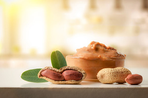 Freshly sliced bread spread with peanut butter on wooden t, a Food & Drink Photo by Davizro's Market