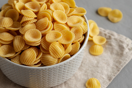 Dry, Uncooked Orecchiette Pasta in a Bowl, side view. Close-up., a Food & Drink Photo by LiudmylaChuhunova