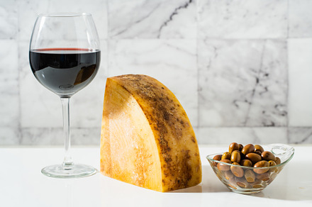 a piece of parmesan or pecorino cheese on a white table and red, a Food & Drink Photo by IriGri