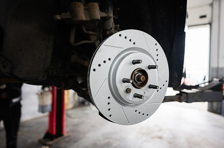 Close-up of car brake disc in an auto repair shop, a Transportation Photo by AS photostudio