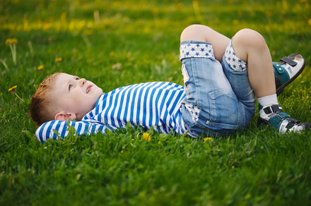Little boy lying on the grass containing green, grass, and boy