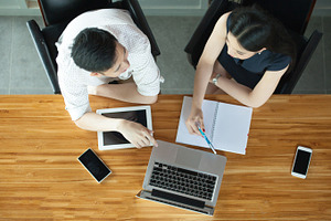 Top view of business or creative people discussing behind the desk containing