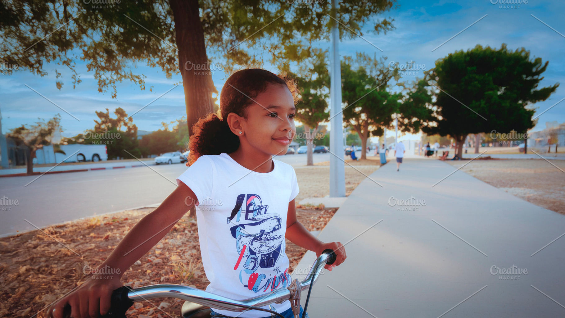 Young girl riding bicycle in city park, a Person Photo by DanFLCreativo