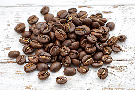 Heap of coffee beans on wooden table, a Food & Drink Photo by AlyaAnd