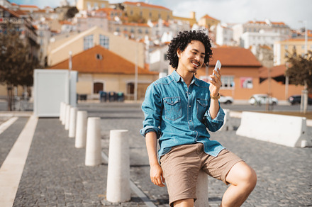 Smiling man on phone, urban scenery, a Person Photo by SkyNext